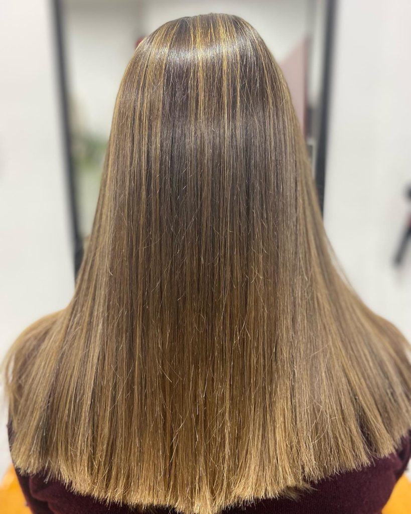 Melena lisa con mechas finas en tonos dorados, trabajada en Peluquería y belleza unisex en Yeste