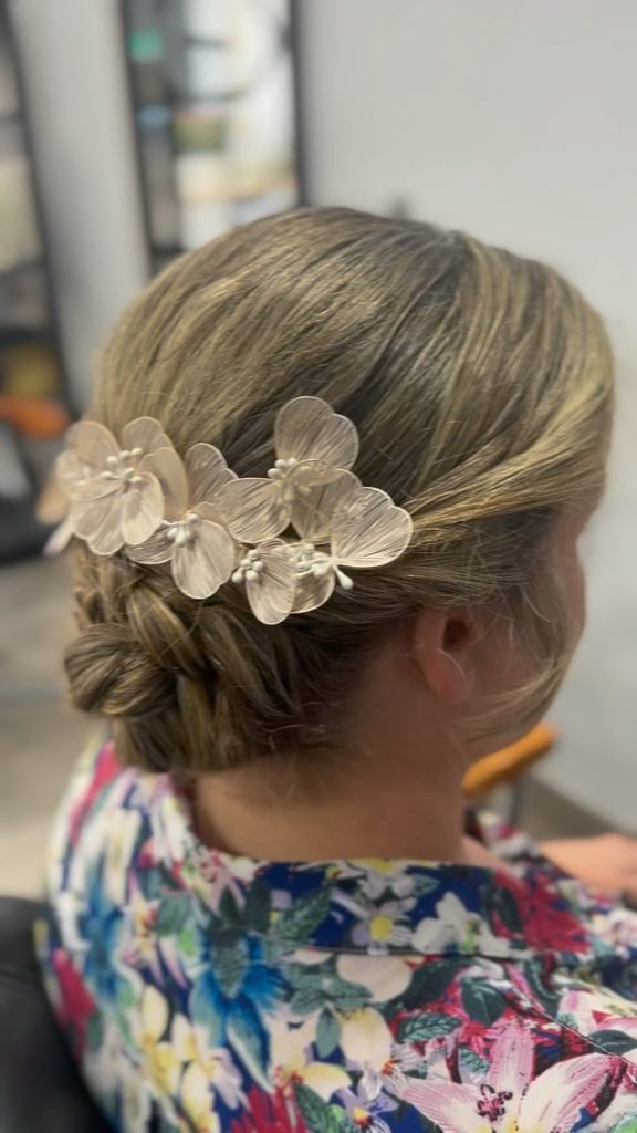 Recogido bajo con trenza y adorno floral blanco, realizado en Peluquería y belleza unisex en Yeste