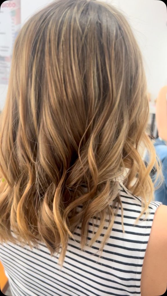 Melena media con ondas suaves y mechas doradas, peinado realizado en Peluquería y belleza unisex en Yeste